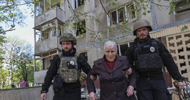 Police officers evacuate a woman from a multi-storey building damaged by a Russian strike on residential neighbourhood in Zaporizhzhia, Ukraine, on Tuesday, April 22, 2025. (AP Photo/Kateryna Klochko)