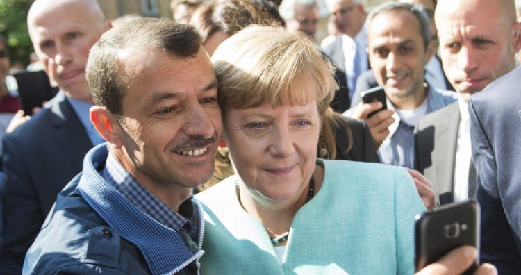 FILE - German Chancellor Angela Merkel taking a selfie with a refugee at the refugee reception center in Berlin, Germany, Sept. 10, 2015. Merkel became the face of a welcoming approach to migrants as people fleeing conflicts in Syria and elsewhere trekked across the Balkans. More than 1 million asylum-seekers entered Germany in 2015-16. (Bernd von Jutrczenka/dpa via AP, File)