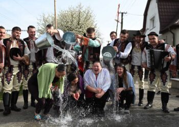 Chlapci v krojoch polievajú dievčatá počas tradičnej oblievačky a šibačky na Veľkonočný pondelok  Foto: SITA/Tomáš Somr