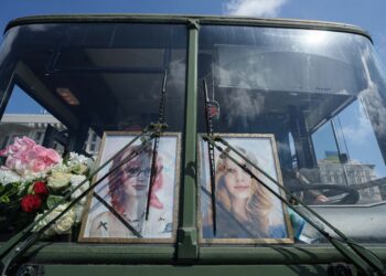 Portréty sestier Ľubavy a Viry Jakovlevových, ktoré začiatkom mája zahynuli pri ruskom raketovom útoku na obytnú budovu, sú umiestnené za čelným sklom autobusu počas ich pohrebu v Kyjeve. Pohreb sa konal v utorok 19. mája 2026. FOTO: SITA/AP Photo/Evgeniy Maloletka