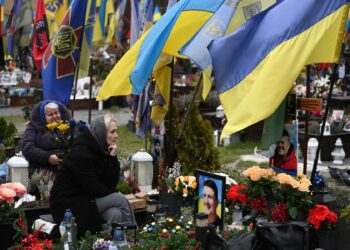 Smutnící ženy u hrobů ukrajinských vojáků na Lyčakovském hřbitově ve Lvově během Dne ozbrojených sil Ukrajiny. FOTO: Profimedia