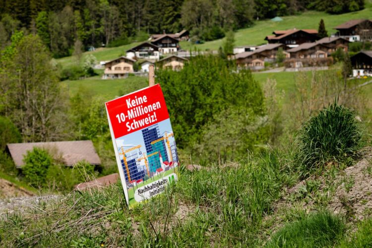 Volební plakát k lidové iniciativě pravicové Švýcarské lidové strany (SVP) s názvem „Ne Švýcarsku s 10 miliony obyvatel“ na poli nedaleko Zweisimmenu ve Švýcarsku. Foto: ČTK / AP / Jean-Christophe Bott/