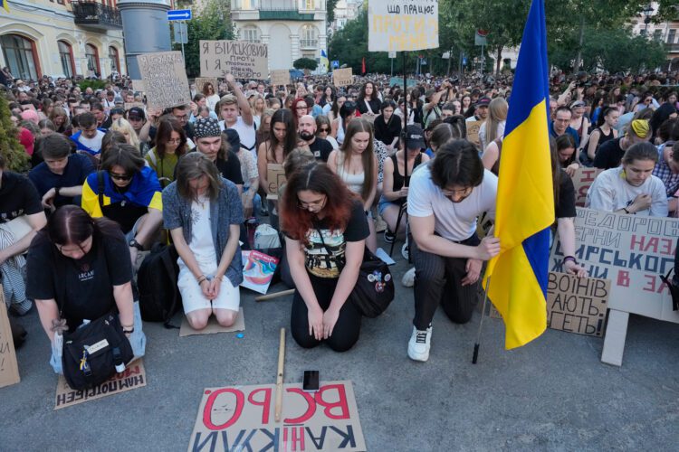 Účastníci protestu v Kyjeve si pokľaknutím a minútou ticha uctili vojakov padlých vo vojne s Ruskom. Sobotňajšia demonštrácia bola namierená proti rozhodnutiu prezidenta Volodymyra Zelenského odvolať ministra obrany Mychajla Fedorova po šiestich mesiacoch vo funkcii. FOTO: SITA/AP Photo/Efrem Lukatsky