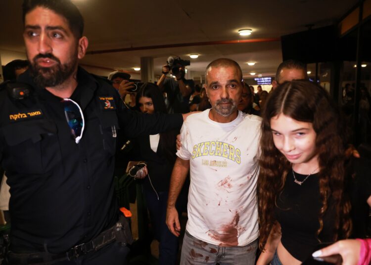 Izraelského cestujúceho Janiva Hajuna v zakrvavenom tričku vítajú na letisku Ben Guriona. Bol jedným z pasažierov, ktorí premohli útočníka v kokpite lietadla spoločnosti Flydubai na linke Dubaj – Tel Aviv a pomohli odvrátiť katastrofu. FOTO: SITA/AP Photo/Tomer Appelbaum.